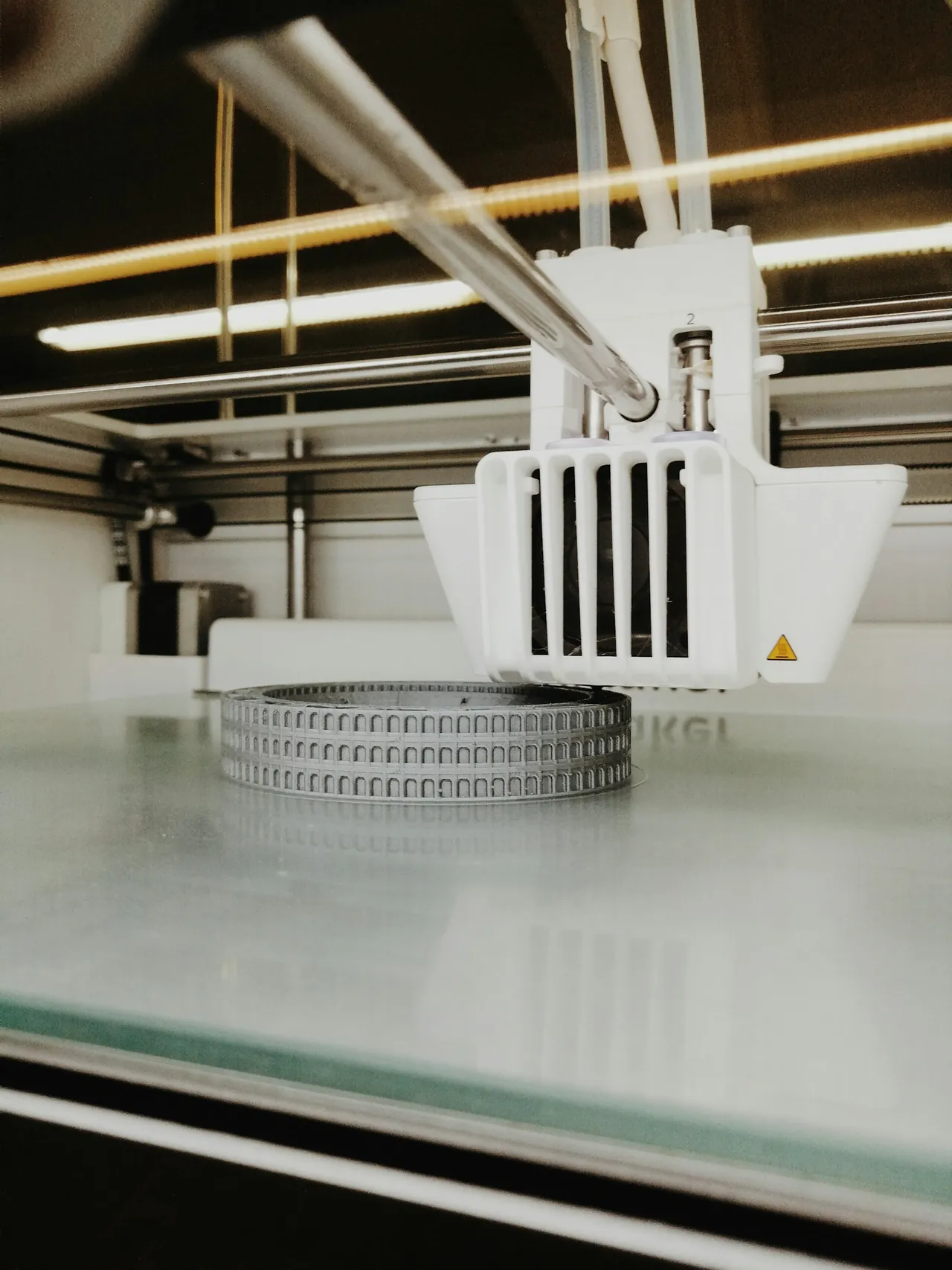 A 3D printer producing a round, toothed mechanical change part