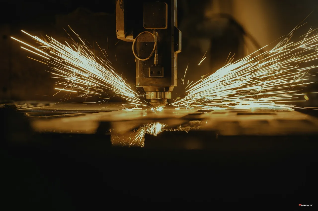 A CNC machine cutting a metal production part with coolant